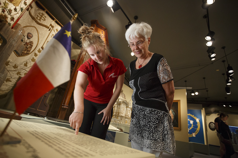 Une aînée découvre notre exposition permanente « Une Acadie Québécoise » au Musée Acadien du Québec.